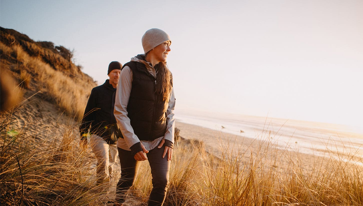 man and woman on hike by beach