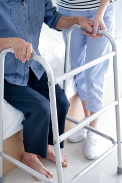 Person using a standard walker sitting on a bed