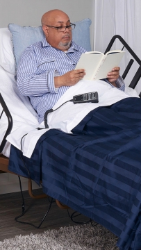 Person sitting up reading in a hospital bed