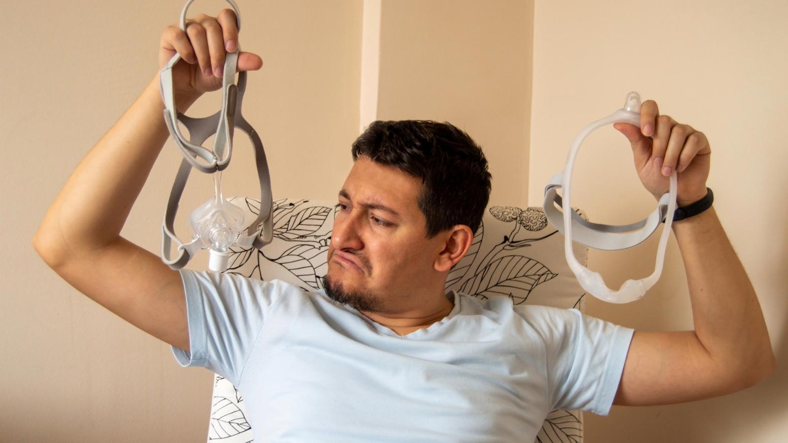 Person holding up 2 CPAP masks comparing them