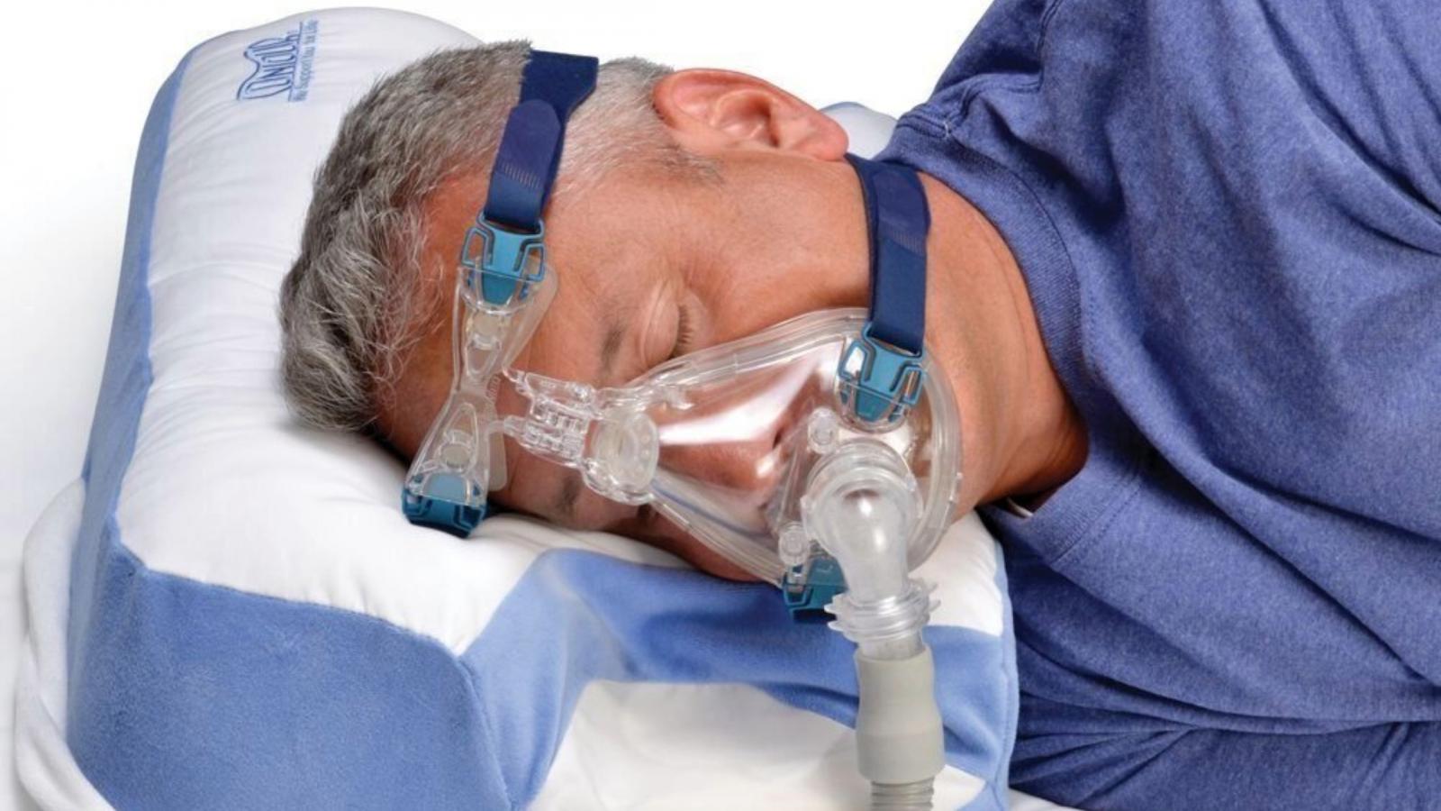 Man with CPAP mask sleeping on his side using the CPAP Multi-mask Pillow