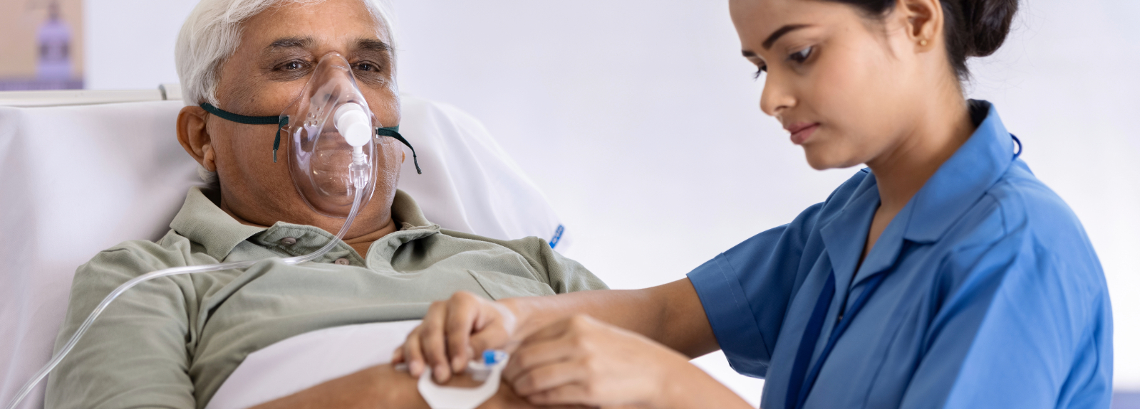 Nurse helping patient on oxygen, in their bed
