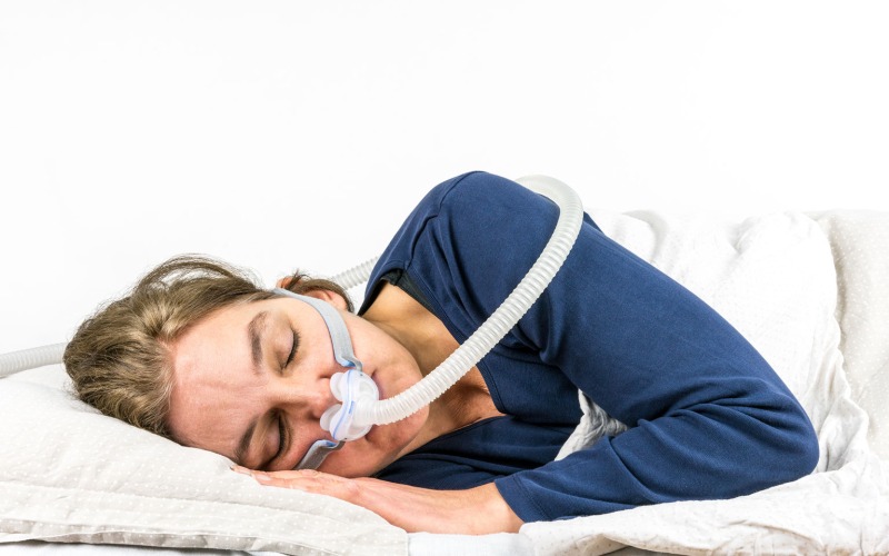 Person wearing a cpap mask sleeping on their side