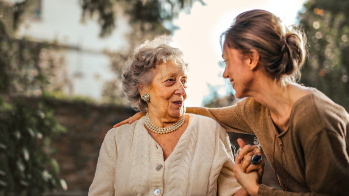 Elderly woman holding hands with younger woman Photo by Andrea Piacquadio from Pexels