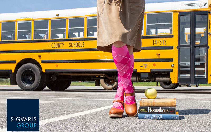Woman with pink compression socks standing in front of a school bus