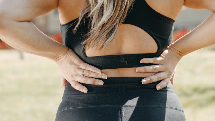 Woman holding her low back and kidney area Photo by Kindel Media from Pexels